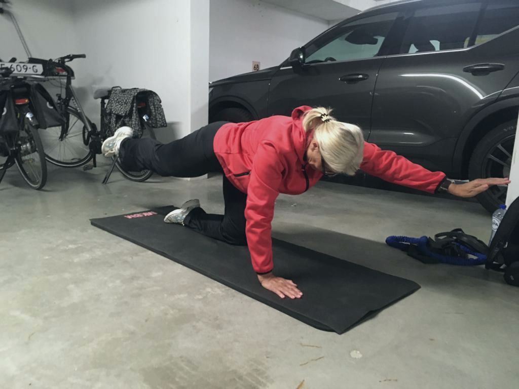 Training op een mat in een garage naast een auto