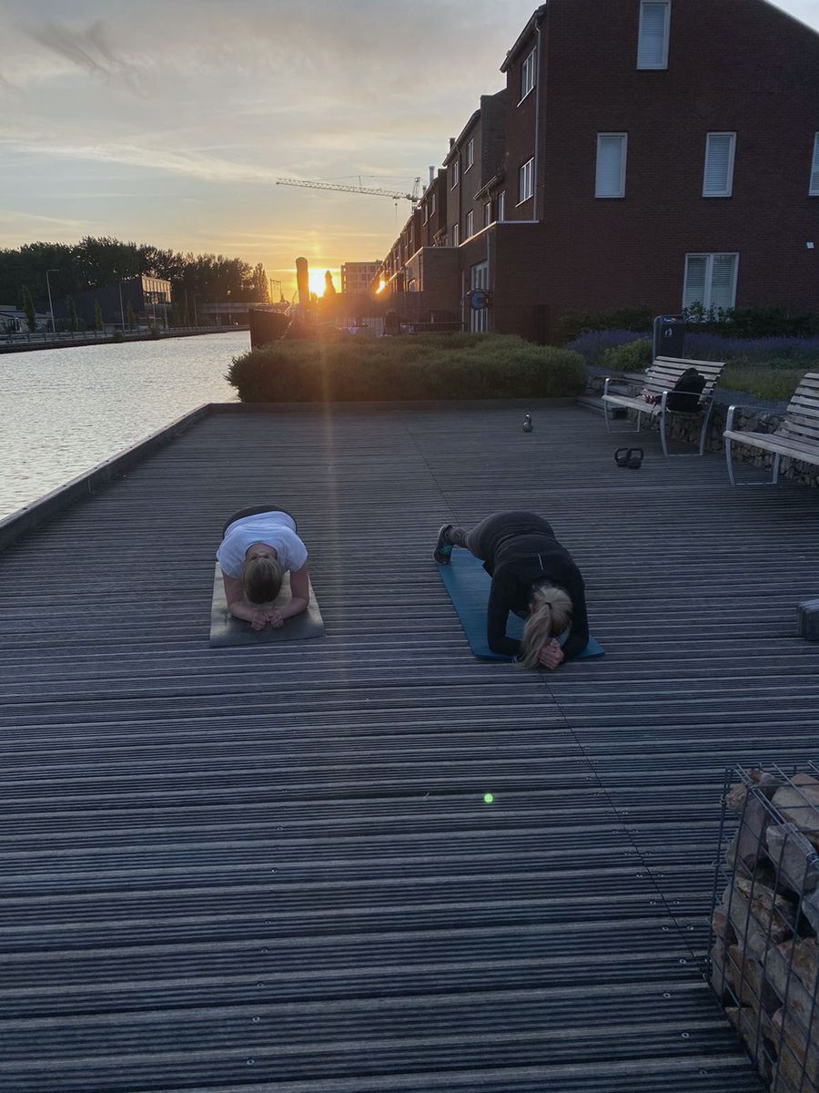 Twee mensen trainen bij zonsopgang op een brede trap